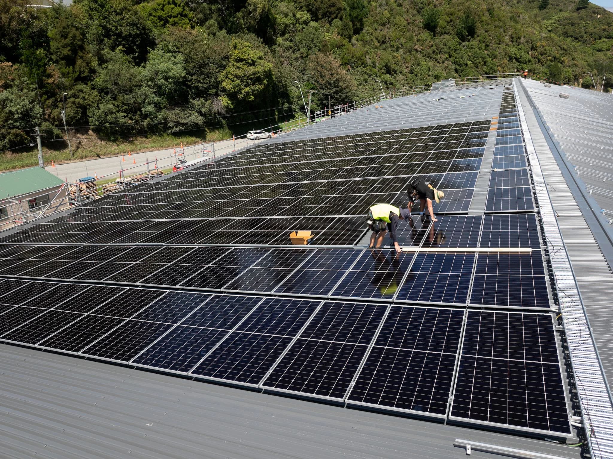 Solar installers working across a large commercial rooftop array